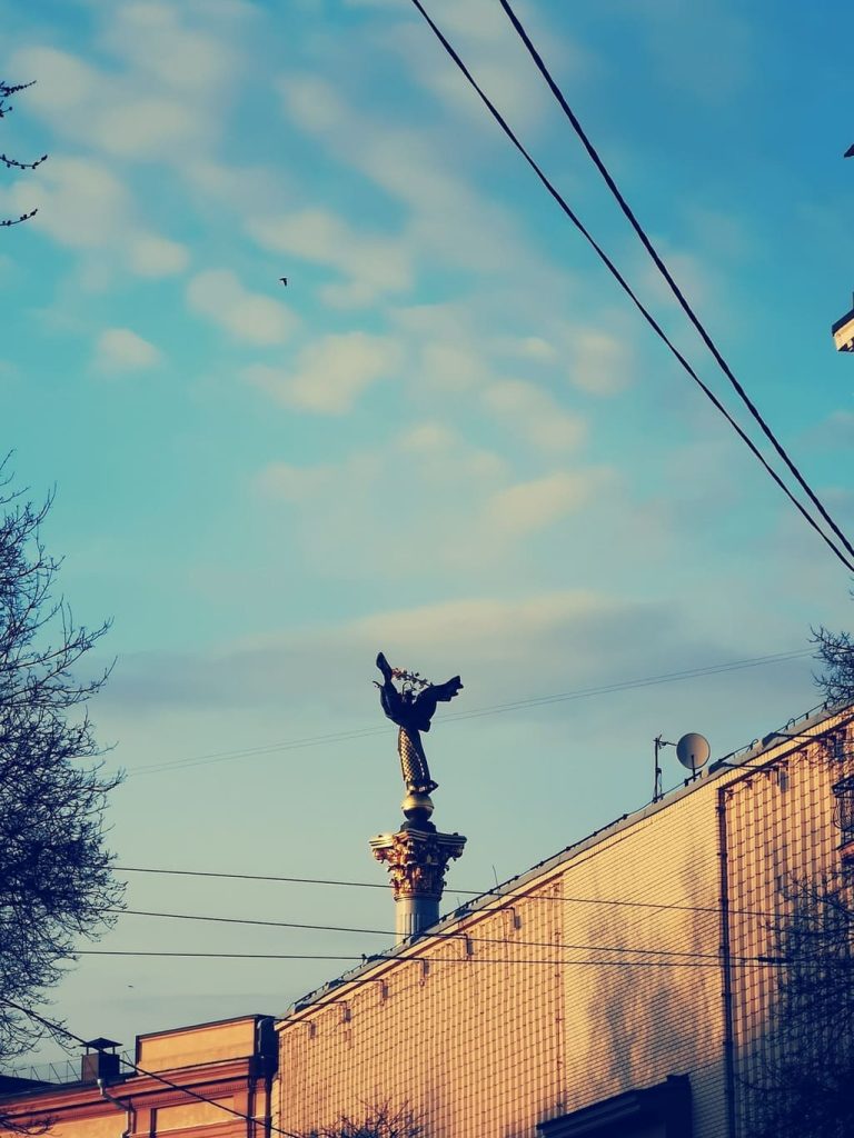 Монумент Незалежності в Києві на фоні неба та будинків по вулиці Городецького.
